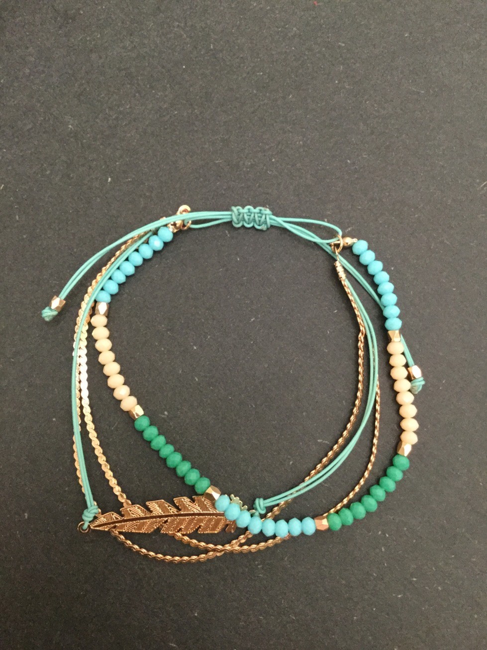 Bracelet - Coulissant multirangs avec plume métallique.