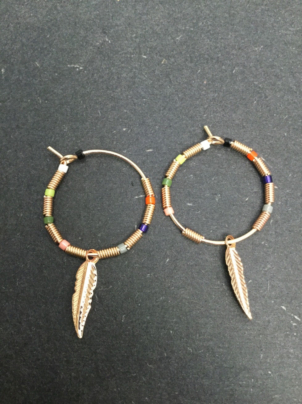 Boucles d'oreilles - Anneau avec perles colorées et plume métallique.